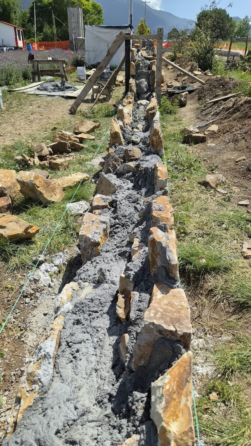 Ejecución de muro de piedra tronada durante obra